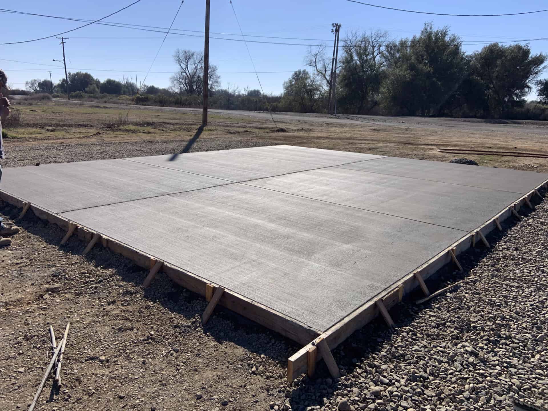 Concrete pad completed and curing before wood forms are removed