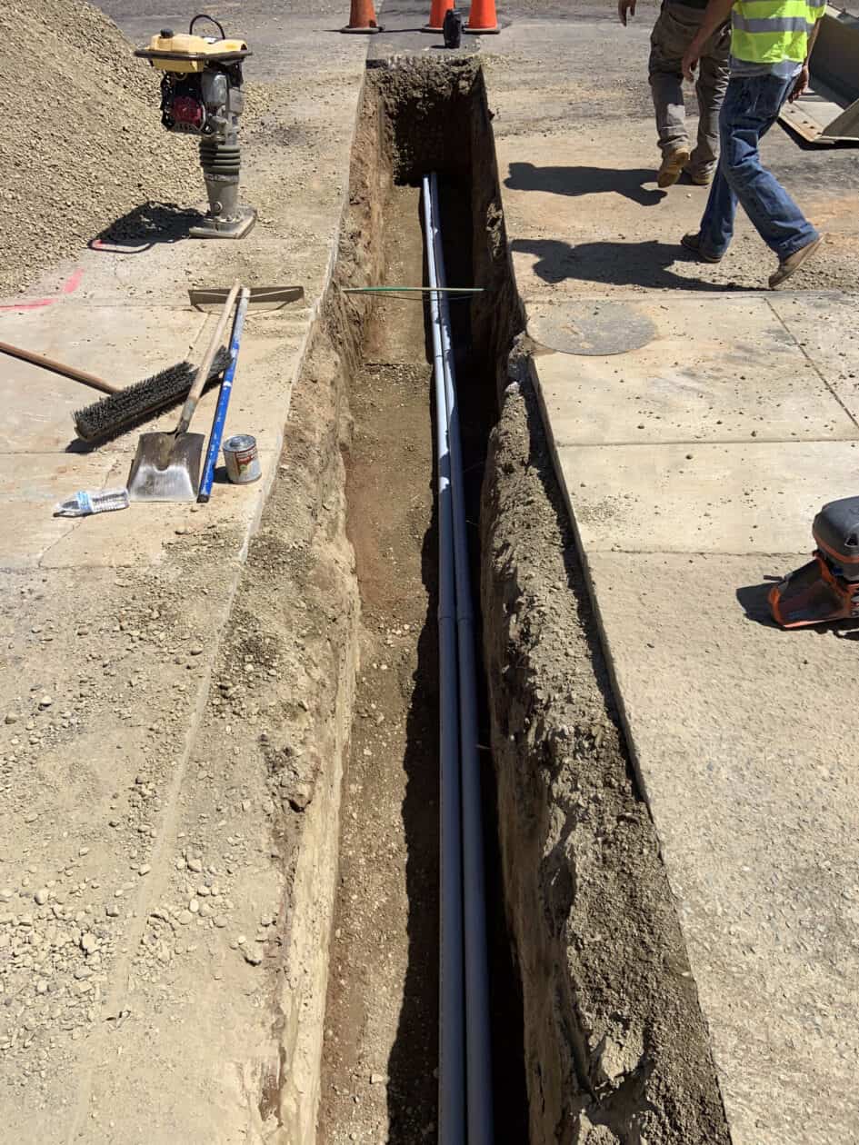 Conduit installed in open trench, ready to be covered