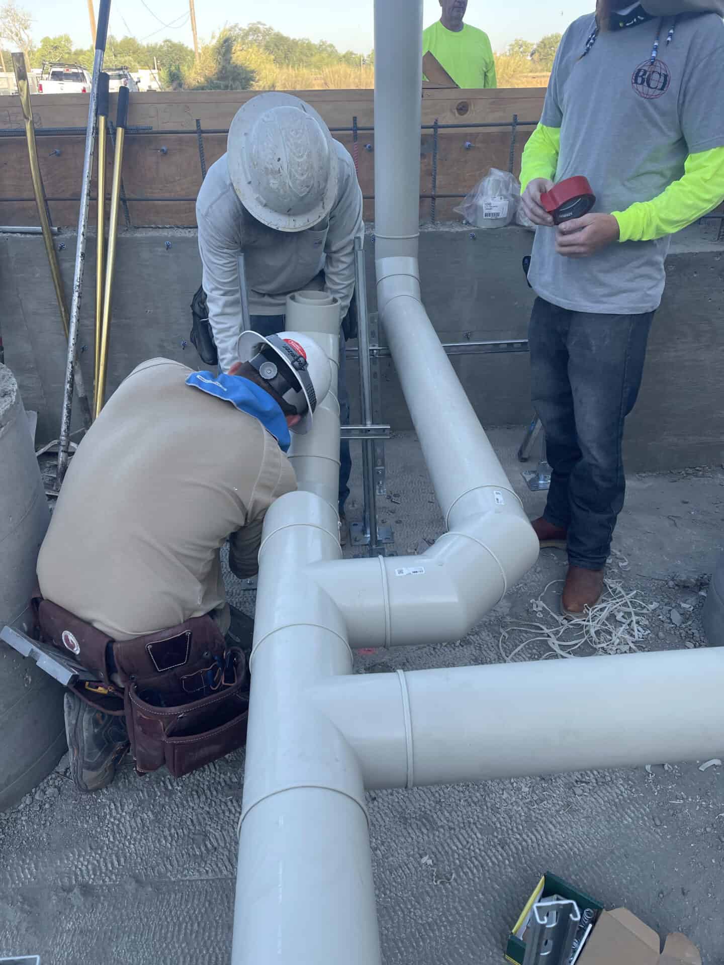 Bayne Construction crew installing pipeline underneath foundation
