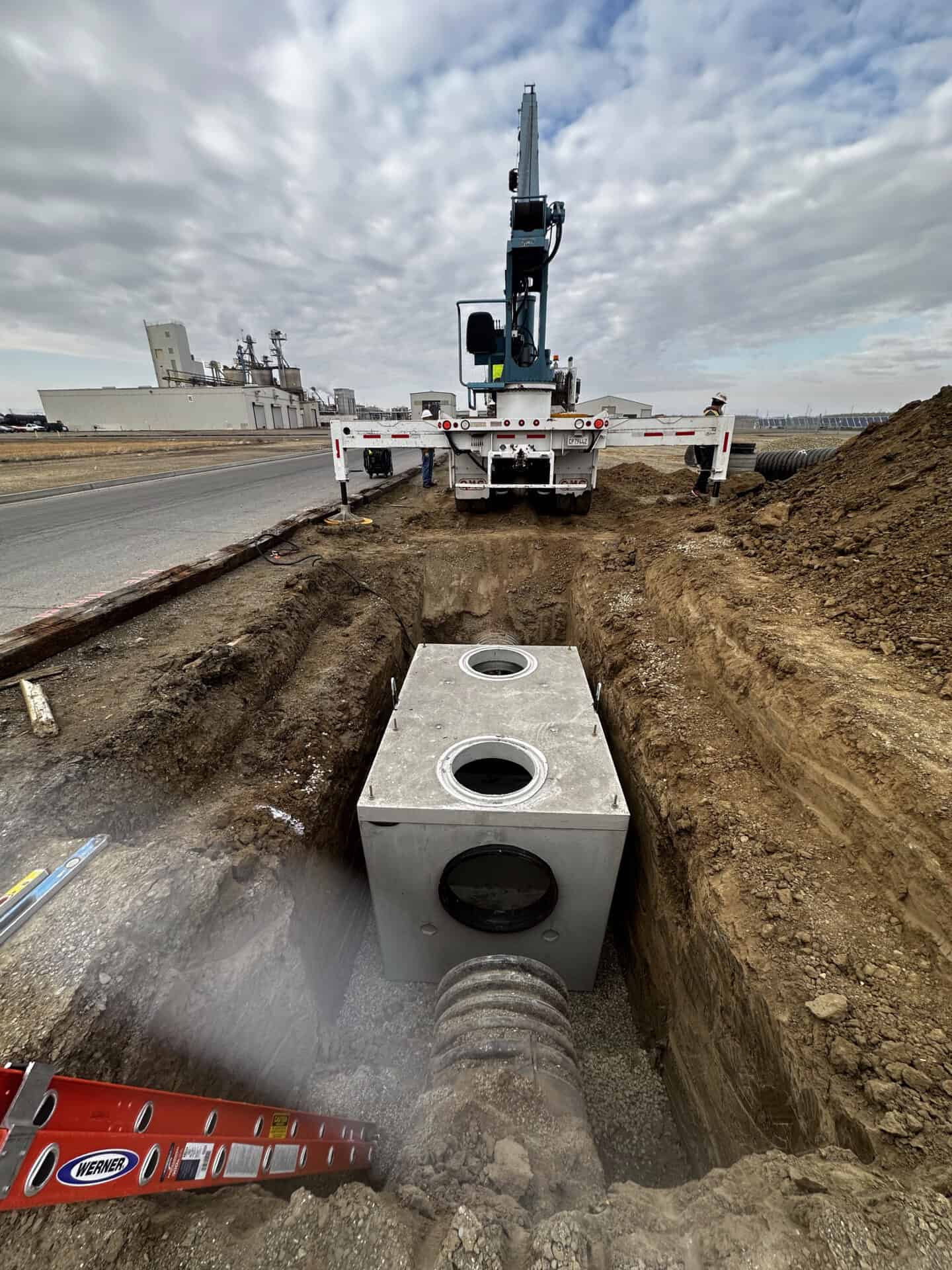 Underground concrete junction box for conduit being installed in trench